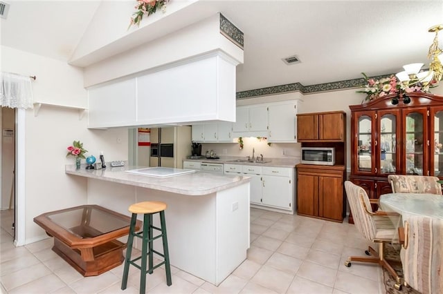 kitchen with sink, white cabinetry, fridge with ice dispenser, and kitchen peninsula