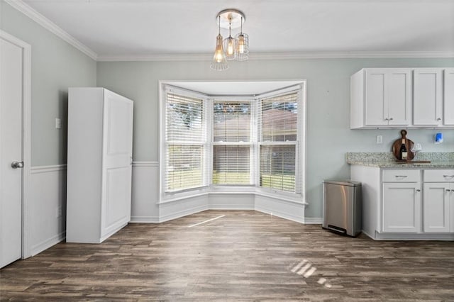 unfurnished dining area with crown molding and dark hardwood / wood-style flooring