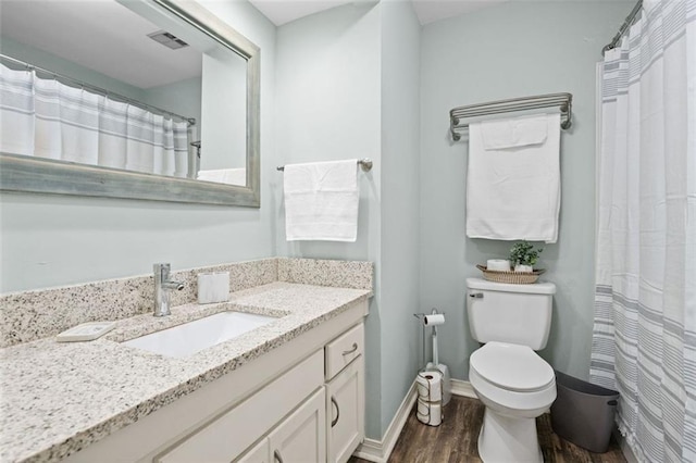 bathroom with vanity, toilet, and wood-type flooring