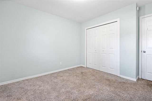 unfurnished bedroom featuring carpet flooring and a closet