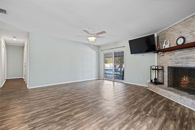 unfurnished living room featuring dark hardwood / wood-style floors, ceiling fan, and a brick fireplace