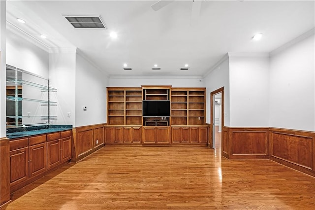 unfurnished living room with ornamental molding, ceiling fan, and light wood-type flooring