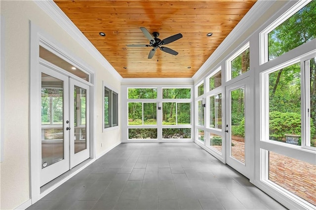 unfurnished sunroom featuring wood ceiling, plenty of natural light, french doors, and ceiling fan