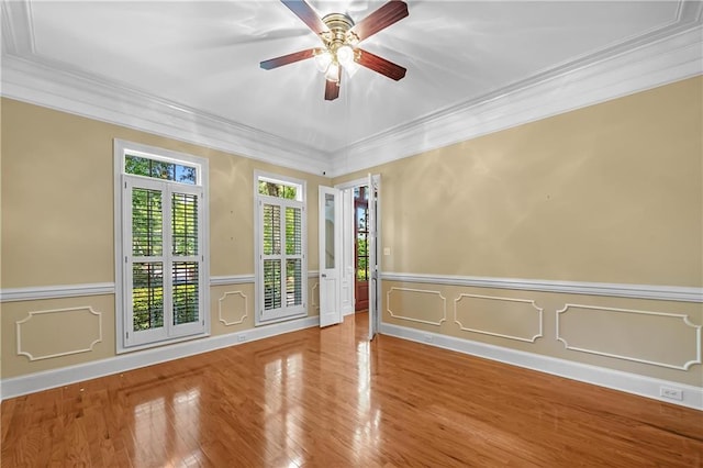 spare room featuring wood-type flooring, ceiling fan, and crown molding