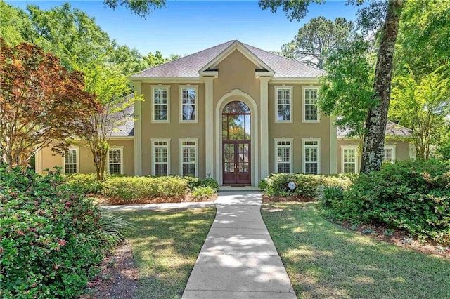 view of front of home with french doors and a front lawn