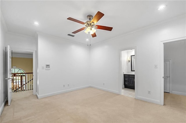 interior space with light carpet, connected bathroom, ceiling fan, and ornamental molding