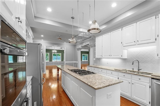 kitchen with a center island, white cabinets, stainless steel appliances, and light hardwood / wood-style flooring