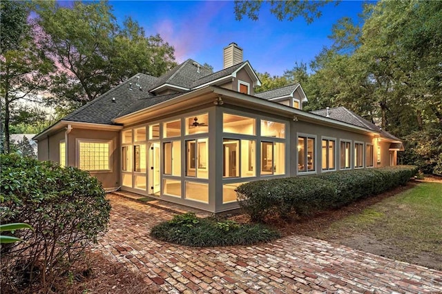 property exterior at dusk with a sunroom