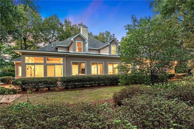 rear view of property featuring a lawn