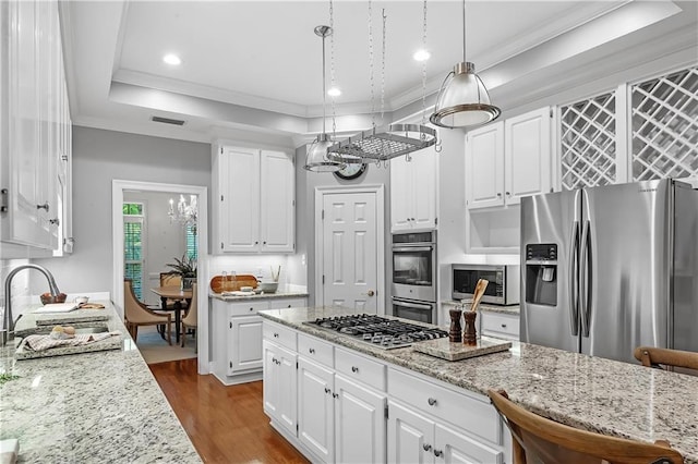 kitchen featuring sink, appliances with stainless steel finishes, white cabinetry, hanging light fixtures, and dark hardwood / wood-style floors