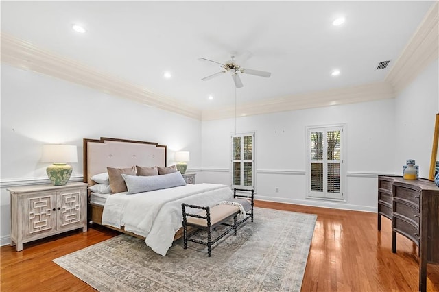 bedroom with crown molding, hardwood / wood-style flooring, and ceiling fan