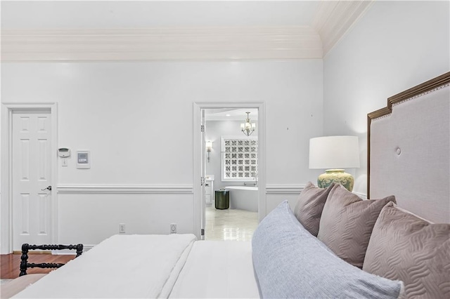 bedroom featuring ornamental molding and ensuite bath