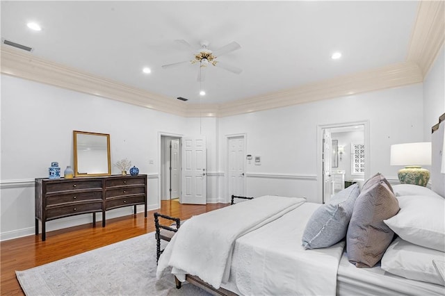 bedroom featuring crown molding, hardwood / wood-style floors, ceiling fan, and ensuite bathroom