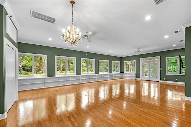 interior space with crown molding, ceiling fan with notable chandelier, a wealth of natural light, and light hardwood / wood-style floors