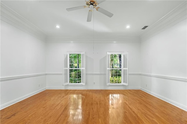 empty room featuring hardwood / wood-style flooring, crown molding, plenty of natural light, and ceiling fan