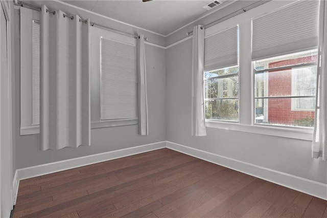 empty room with wood-type flooring and ornamental molding