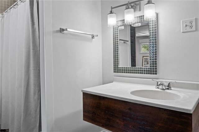 bathroom featuring a shower with shower curtain and vanity