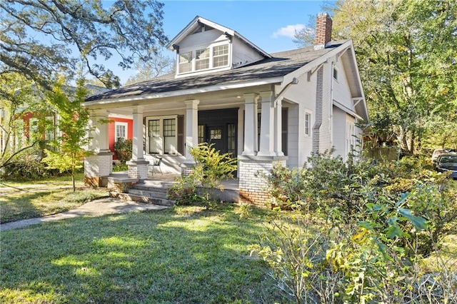 view of front of house featuring covered porch and a front yard