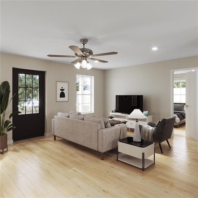 living room featuring light wood-type flooring, plenty of natural light, and ceiling fan