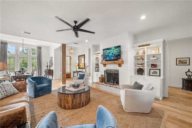 living room featuring light wood-style floors, ceiling fan, a brick fireplace, recessed lighting, and baseboards