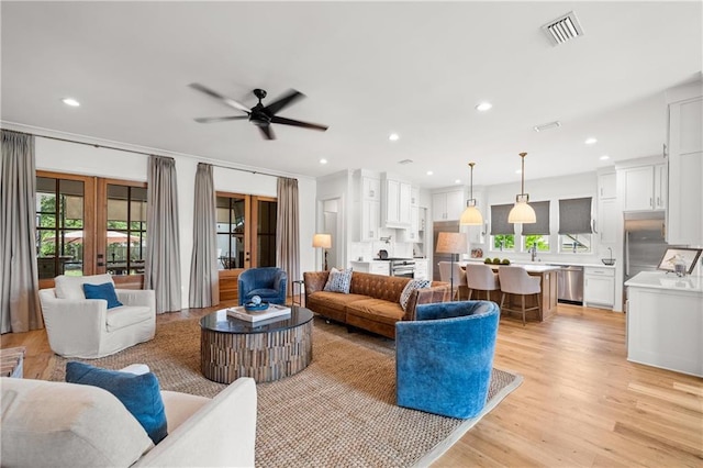 living area with plenty of natural light, a ceiling fan, recessed lighting, and light wood-type flooring