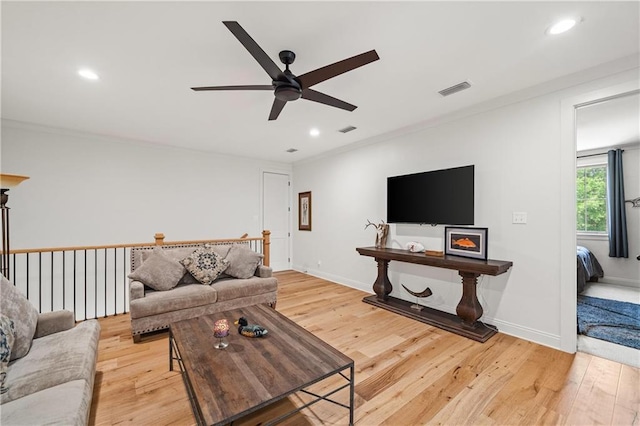 living area with ceiling fan, light wood finished floors, recessed lighting, ornamental molding, and baseboards