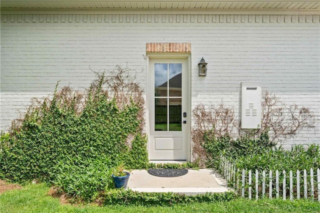 doorway to property featuring brick siding