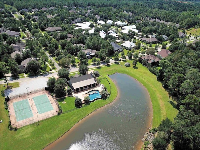 aerial view of property and surrounding area featuring a pool, a large body of water, and nearby suburban area
