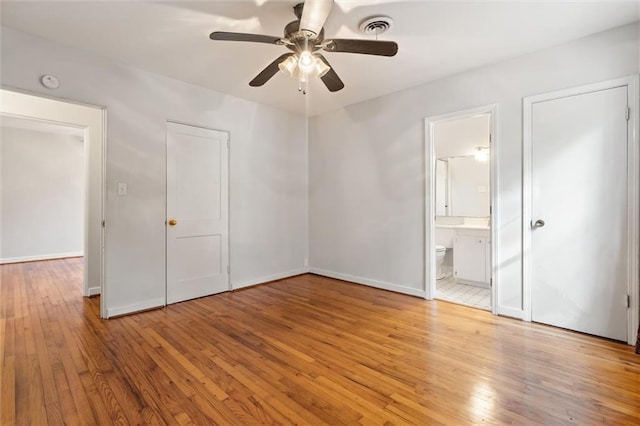 unfurnished bedroom with ceiling fan, connected bathroom, and light hardwood / wood-style flooring