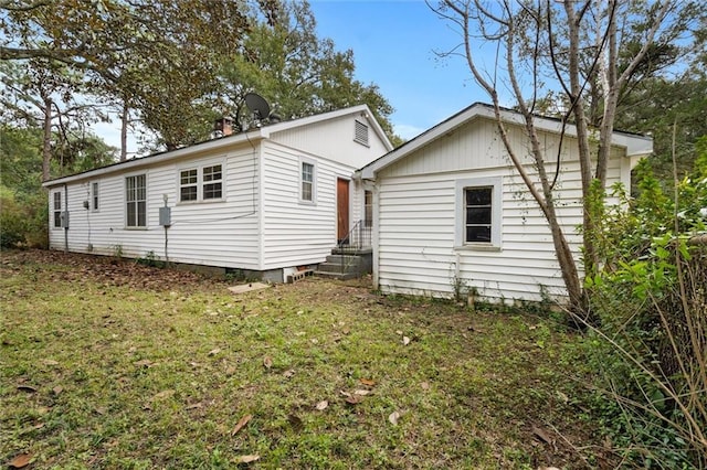 rear view of property featuring a yard