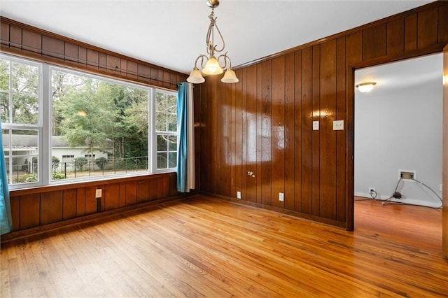 unfurnished dining area featuring light hardwood / wood-style floors, a wealth of natural light, and a chandelier