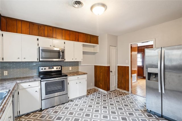 kitchen with white cabinetry, stainless steel appliances, and tasteful backsplash