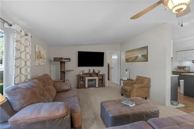 living room with ceiling fan, light carpet, and a toaster