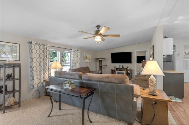 living room featuring light wood-type flooring and a ceiling fan