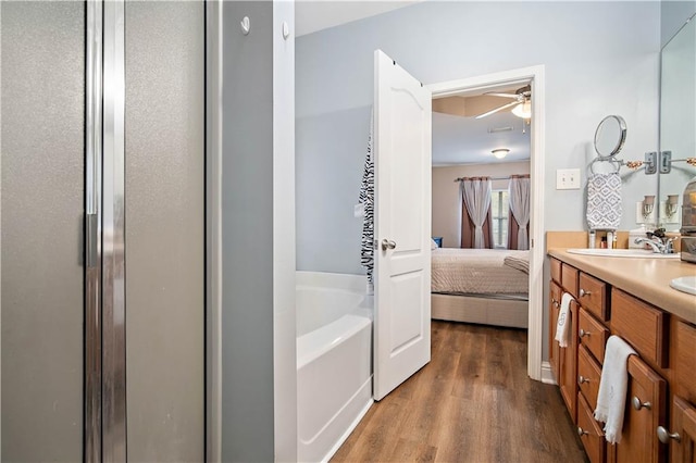 bathroom featuring hardwood / wood-style flooring, ceiling fan, vanity, and plus walk in shower