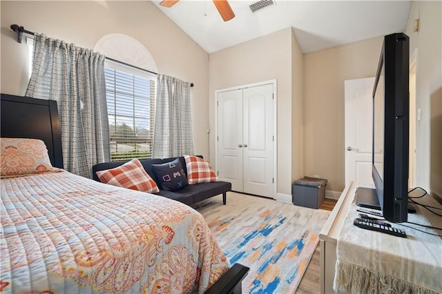 bedroom featuring a closet, light wood-type flooring, lofted ceiling, and ceiling fan