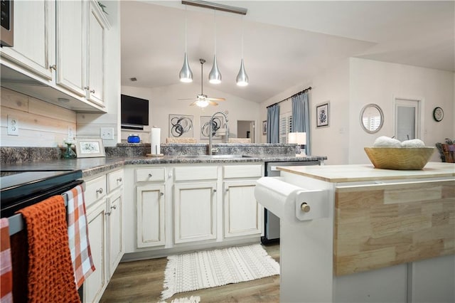 kitchen featuring dark wood-type flooring, kitchen peninsula, vaulted ceiling, and white cabinets