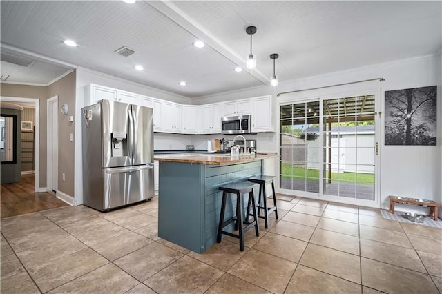 19565 4th St N, Citronelle, AL 36522 - kitchen featuring appliances with stainless steel finishes, crown molding, white cabinetry, a breakfast bar area, and decorative light fixtures