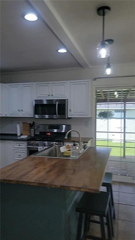 19565 4th St N, Citronelle, AL 36522 - kitchen with butcher block counters, stainless steel appliances, white cabinets, recessed lighting, and tile patterned flooring