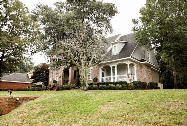 view of front of house featuring covered porch and a front lawn