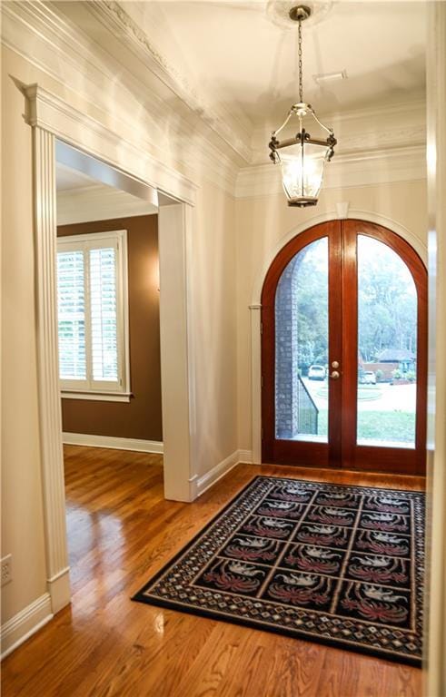 foyer featuring french doors, ornamental molding, and wood-type flooring