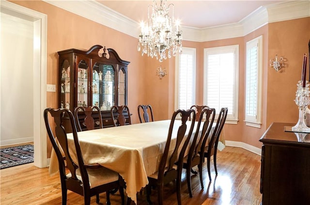 dining room featuring light hardwood / wood-style flooring, ornamental molding, and a chandelier