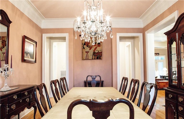 dining room featuring a notable chandelier, ornamental molding, and light hardwood / wood-style floors