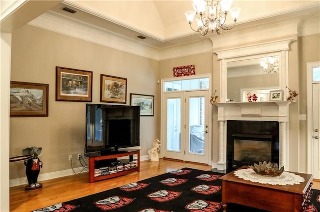 living room featuring crown molding, wood-type flooring, and a chandelier