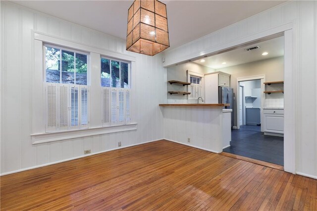 1660 Laurel St, Mobile, AL 36604 - kitchen with open shelves, wood-type flooring, a peninsula, freestanding refrigerator, and hanging light fixtures