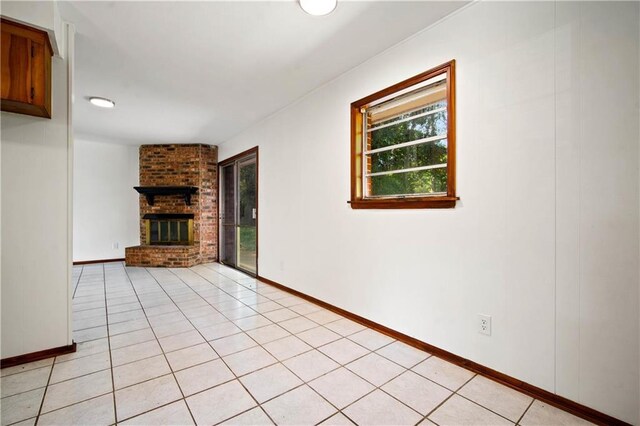 754 Pinemont Dr, Mobile, AL 36609 - unfurnished living room featuring plenty of natural light, a brick fireplace, baseboards, and light tile patterned flooring