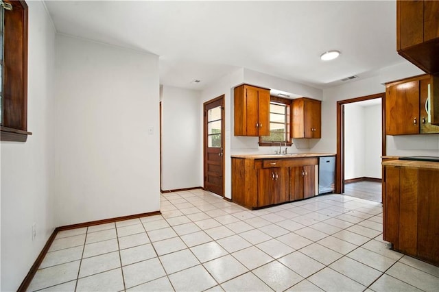 754 Pinemont Dr, Mobile, AL 36609 - kitchen featuring dishwashing machine, light countertops, brown cabinets, a sink, and baseboards