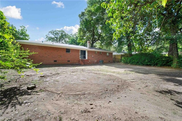 754 Pinemont Dr, Mobile, AL 36609 - back of property with crawl space, brick siding, a chimney, fence, and entry steps