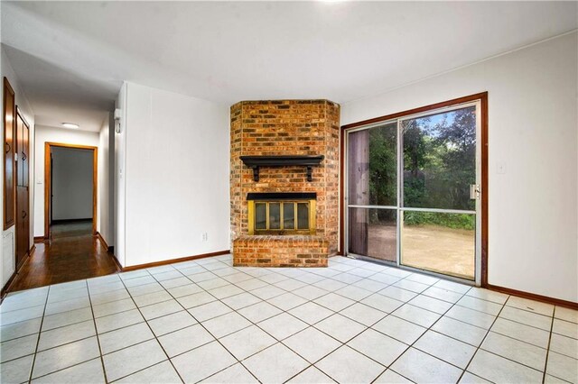 754 Pinemont Dr, Mobile, AL 36609 - unfurnished living room featuring baseboards, a brick fireplace, and light tile patterned flooring