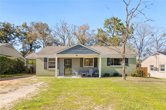 rear view of property featuring a yard and brick siding